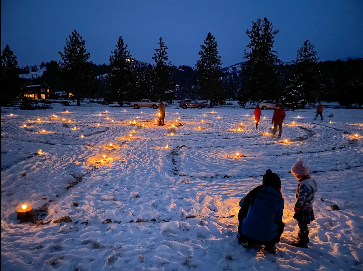 Candles lining a labyrinth path in the snow