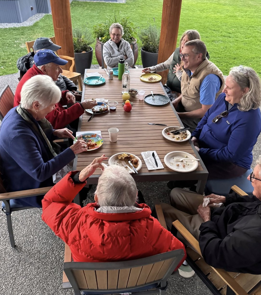 Friends laughing around a shared table after a potluck