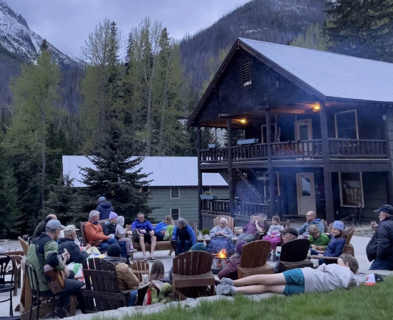 The fellowship gathered around a fire outside a mountain lodge on retreat